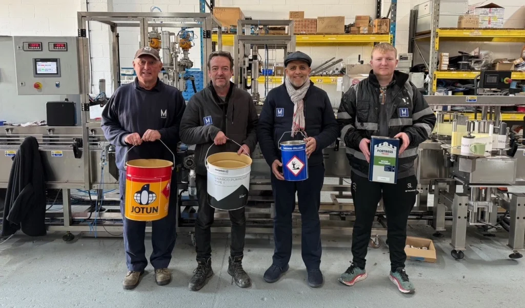 Mount Filling Systems team in Dewsbury workshop holding industrial cans tins and pails