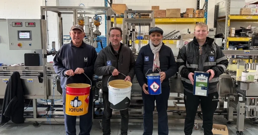 Mount Filling Systems team in Dewsbury workshop holding industrial cans tins and pails